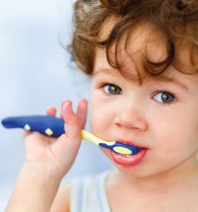 Young brown haired child brushing teeth