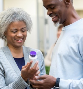 Seniors reading medicine bottle labels in pharmacy