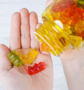 Child Holding Multicolored Gummy Vitamins