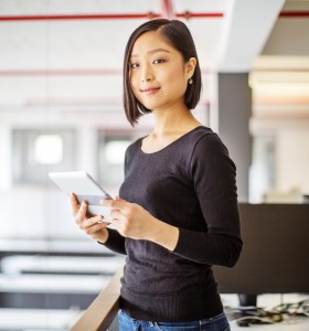 Young Asian woman holding a tablet smiling