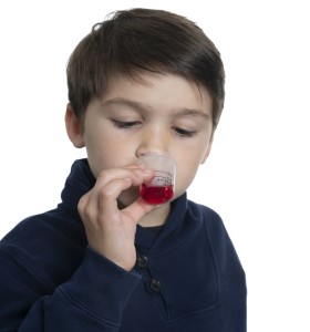 Young Boy Drinking Medicine against white background