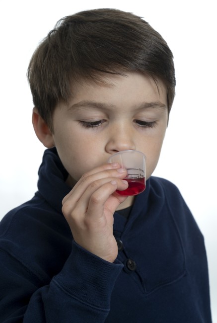 Hispanic/Latinx Young Boy Drinking Medicine against white background