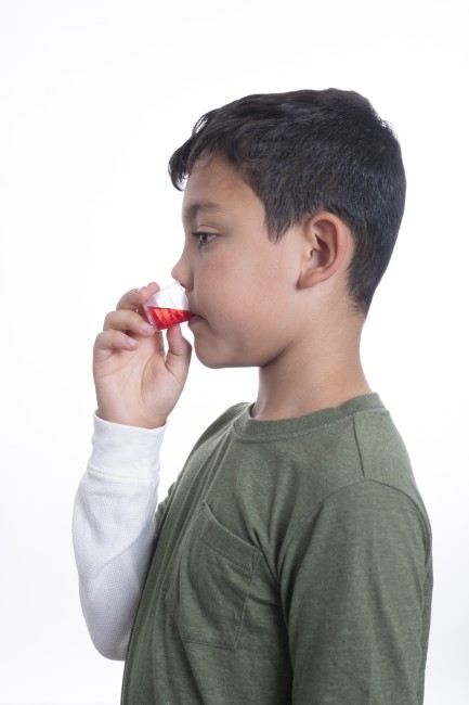 Hispanic/Latinx Boy in Green Shirt Drinking Medicine