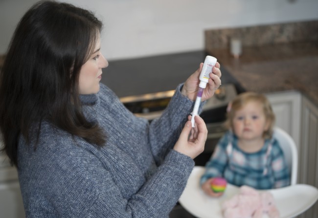 Caucasian/White Woman measuring medicine for Caucasian/White toddler