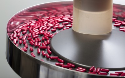 red capsules being sorted in a circular hopper red capsules being sorted in a circular hopper