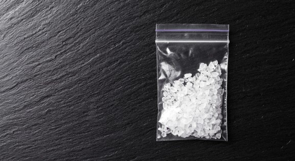 meth crystals in a plastic bag on a dark background