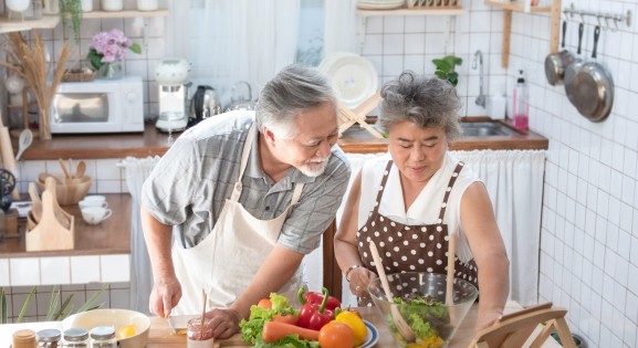 elderly couple of east Asian descent cooking together
