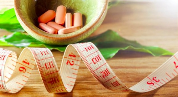 Image of weight loss pills and measuring tape